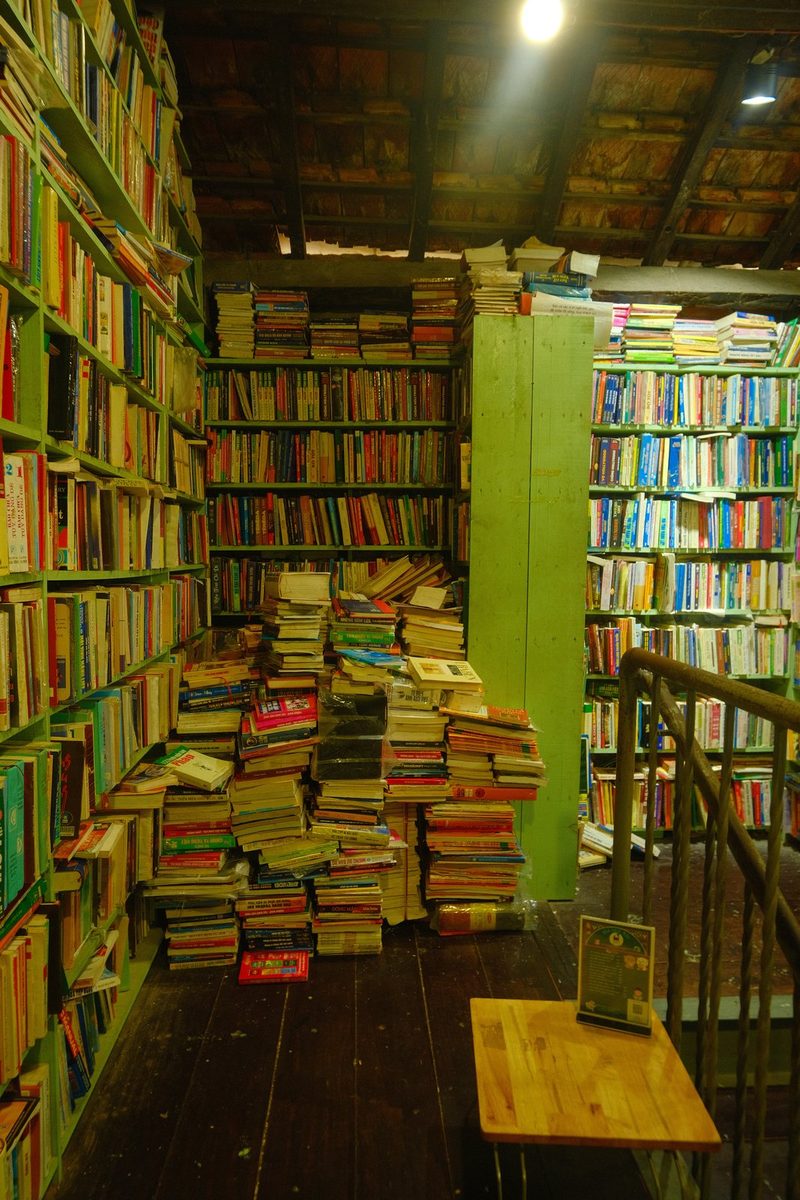 A room filled with books and a wooden table, possibly a library or bookstore.