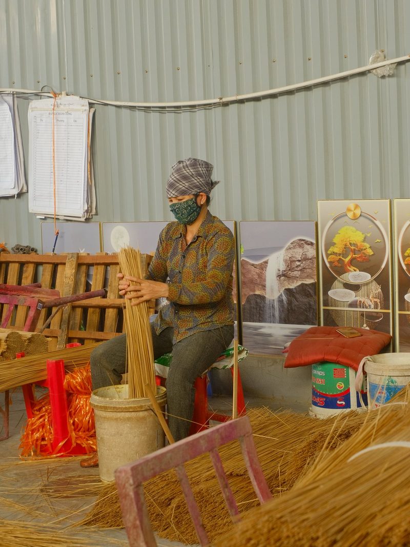 A man is working in a workshop, surrounded by materials and tools.