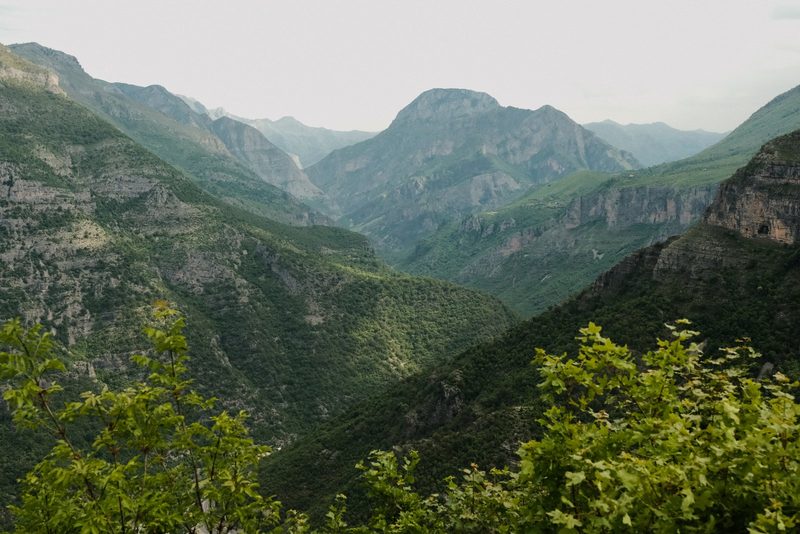 A mountainous landscape with lush greenery and a hazy sky.