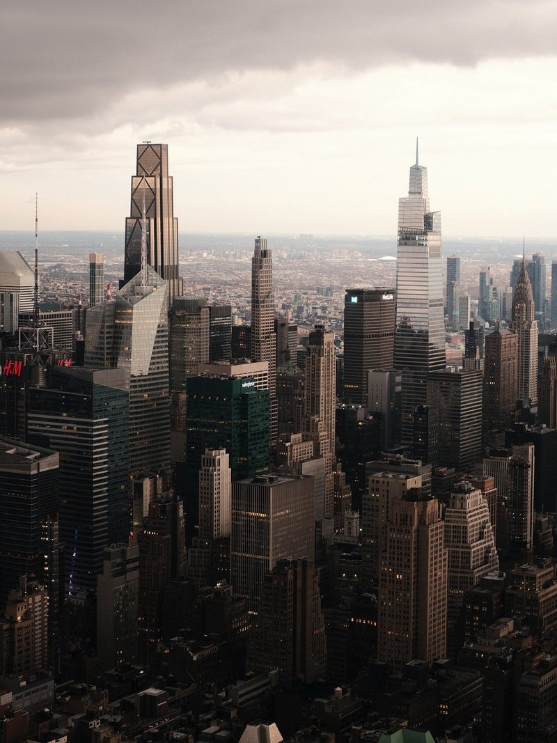 A cityscape with many tall buildings under a cloudy sky.