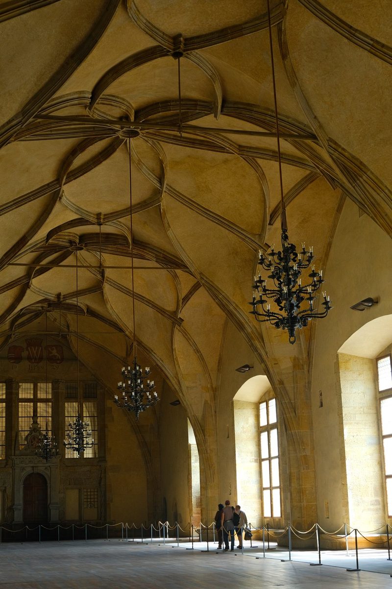 A large room with high ceilings and ornate chandeliers, possibly in a historic building or museum.
