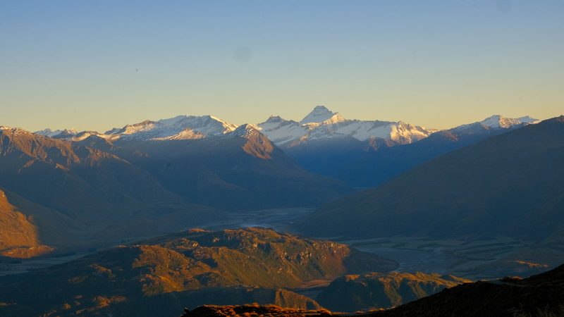 Snow-capped mountains and valleys in a mountainous region, possibly New Zealand.
